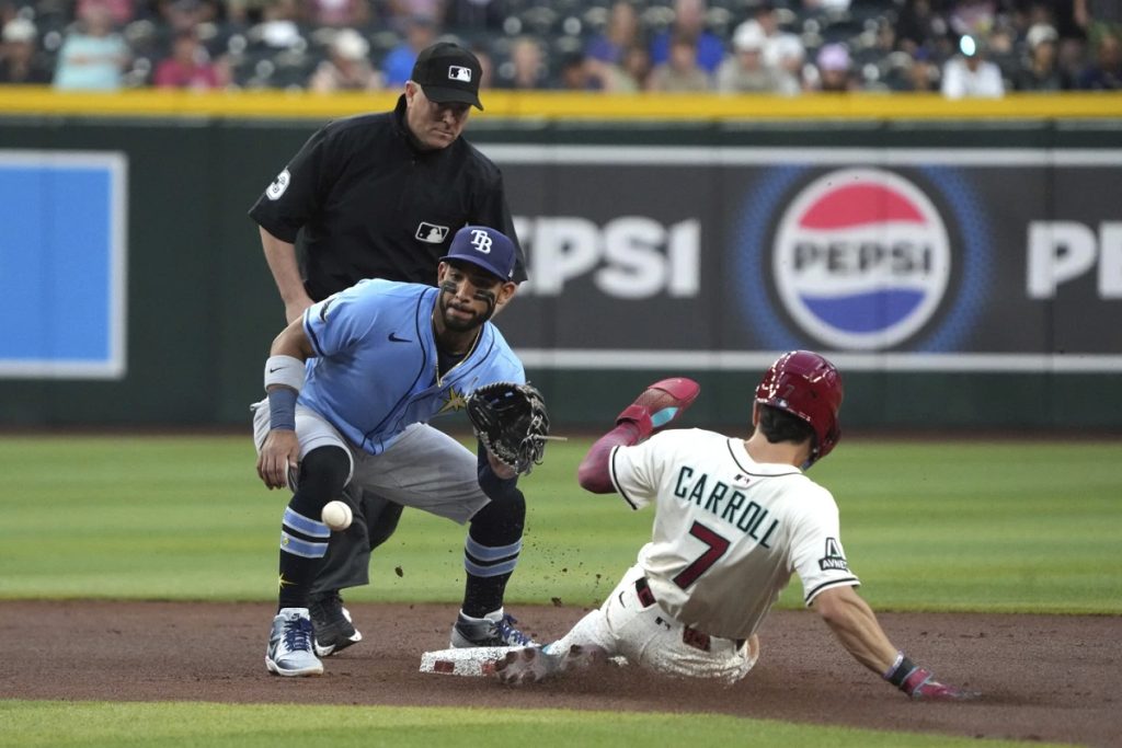 Arizona Diamondbacks' Corbin Carroll (7) steals second base under a tag by Tampa Bay Rays shortstop José Caballero, front left, in the first inning during a baseball game, Thursday, April 24, 2025, in Phoenix. (AP Photo/Rick Scuteri)