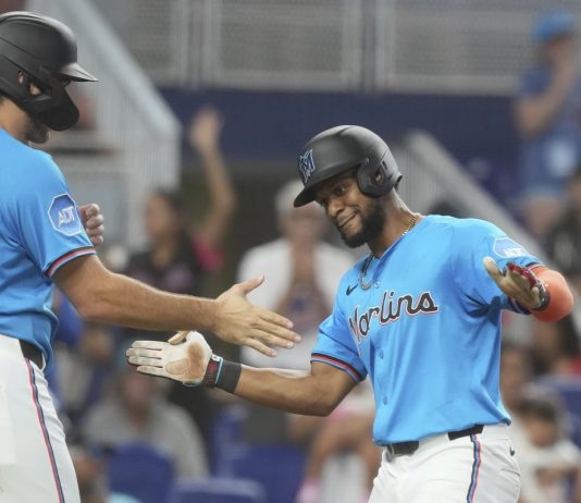 Miami Marlins' Otto Lopez, right, celebrates with Matt Mervis, left, after hitting a three-run home run during the fourth inning of a baseball game against the Tampa Bay Rays, Sunday, May 18, 2025, in Miami. (AP Photo/Marta Lavandier)