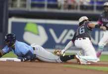 Tampa Bay Rays' Yandy Díaz (2) as Miami Marlins short stop Javier Sanoja (46) is late with the tags during the first inning of a baseball game, Saturday, May 17, 2025, in Miami. (AP Photo/Marta Lavandier)