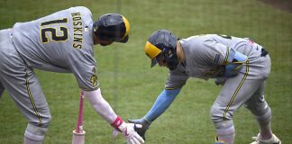 Milwaukee Brewers' Christian Yelich, right, celebrates after his solo home run with Rhys Hoskins (12) during the fourth inning of a baseball game against the Tampa Bay Rays, Sunday, May 11, 2025, in Tampa, Fla. (AP Photo/Phelan M. Ebenhack)