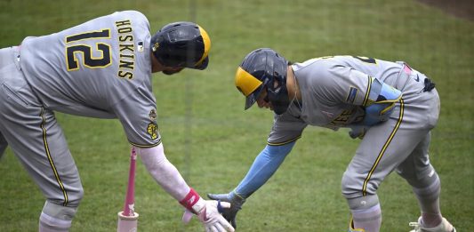 Milwaukee Brewers' Christian Yelich, right, celebrates after his solo home run with Rhys Hoskins (12) during the fourth inning of a baseball game against the Tampa Bay Rays, Sunday, May 11, 2025, in Tampa, Fla. (AP Photo/Phelan M. Ebenhack)