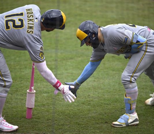 Milwaukee Brewers' Christian Yelich, right, celebrates after his solo home run with Rhys Hoskins (12) during the fourth inning of a baseball game against the Tampa Bay Rays, Sunday, May 11, 2025, in Tampa, Fla. (AP Photo/Phelan M. Ebenhack)
