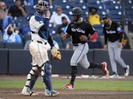 Miami Marlins' Otto Lopez scores in front of Tampa Bay Rays catcher Danny Jansen on an RBI single by Heriberto Hernandez off pitcher Garrett Cleavinger during the 10th inning of a baseball game Saturday, June 7, 2025, in Tampa, Fla. (AP Photo/Chris O'Meara)