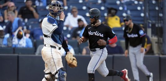 Miami Marlins' Otto Lopez scores in front of Tampa Bay Rays catcher Danny Jansen on an RBI single by Heriberto Hernandez off pitcher Garrett Cleavinger during the 10th inning of a baseball game Saturday, June 7, 2025, in Tampa, Fla. (AP Photo/Chris O'Meara)