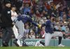 Tampa Bay Rays' Yandy Díaz is congratulated by teammate Junior Caminero (13) after scoring on a single by Jonathan Aranda during the seventh inning of a baseball game against the Boston Red Sox at Fenway Park, Monday, June 9, 2025, in Boston. (AP Photo/Mary Schwalm)