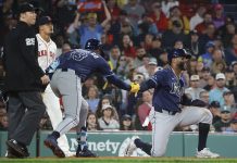 Tampa Bay Rays' Yandy Díaz is congratulated by teammate Junior Caminero (13) after scoring on a single by Jonathan Aranda during the seventh inning of a baseball game against the Boston Red Sox at Fenway Park, Monday, June 9, 2025, in Boston. (AP Photo/Mary Schwalm)