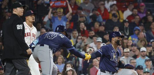 Tampa Bay Rays' Yandy Díaz is congratulated by teammate Junior Caminero (13) after scoring on a single by Jonathan Aranda during the seventh inning of a baseball game against the Boston Red Sox at Fenway Park, Monday, June 9, 2025, in Boston. (AP Photo/Mary Schwalm)