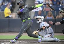 Tampa Bay Rays' Junior Caminero, left, watches the flight of the ball after hitting a three-run home run as Baltimore Orioles catcher Jacob Stallings and home plate umpire Sean Barber, right, look on during the first inning of a baseball game, Friday, July 18, 2025, in Tampa, Fla. (AP Photo/Phelan M. Ebenhack)