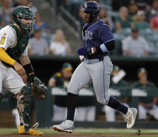 Tampa Bay Rays’ Yandy Diaz, right, scores during the third inning of a baseball game against the Athletics, Monday, Aug. 11, 2025, in West Sacramento, Calif. (AP Photo/Sergio Estrada)