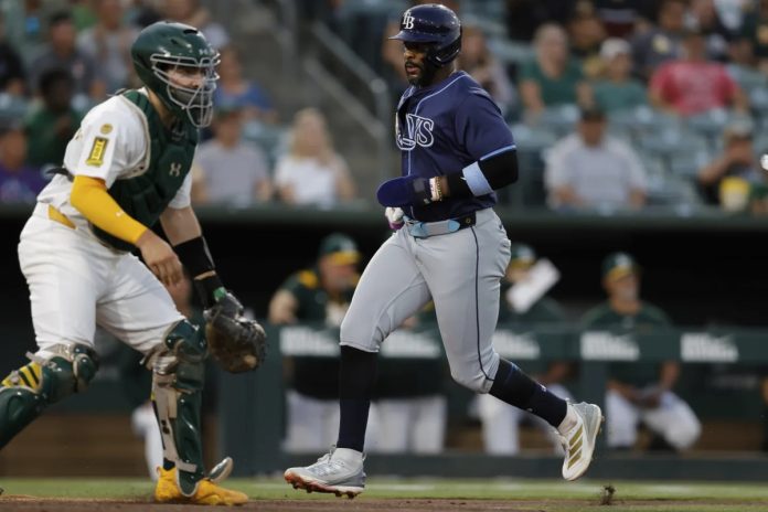 Tampa Bay Rays’ Yandy Diaz, right, scores during the third inning of a baseball game against the Athletics, Monday, Aug. 11, 2025, in West Sacramento, Calif. (AP Photo/Sergio Estrada)