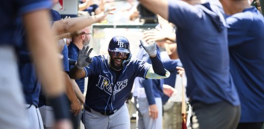 Tampa Bay Rays' Junior Caminero is greeted by teammates in the dugout after hitting a home run during the third inning of a baseball game against the Los Angeles Angels Wednesday, Aug. 6, 2025, in Anaheim, Calif. (AP Photo/William Liang)