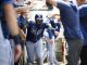 Tampa Bay Rays' Junior Caminero is greeted by teammates in the dugout after hitting a home run during the third inning of a baseball game against the Los Angeles Angels Wednesday, Aug. 6, 2025, in Anaheim, Calif. (AP Photo/William Liang)