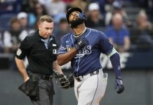 Tampa Bay Rays' Junior Caminero gestures as he crosses home plate with a home run in the fifth inning of a baseball game against the Cleveland Guardians in Cleveland, Monday, Aug. 25, 2025. (AP Photo/Sue Ogrocki)