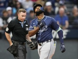 Tampa Bay Rays' Junior Caminero gestures as he crosses home plate with a home run in the fifth inning of a baseball game against the Cleveland Guardians in Cleveland, Monday, Aug. 25, 2025. (AP Photo/Sue Ogrocki)