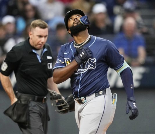 Tampa Bay Rays' Junior Caminero gestures as he crosses home plate with a home run in the fifth inning of a baseball game against the Cleveland Guardians in Cleveland, Monday, Aug. 25, 2025. (AP Photo/Sue Ogrocki)