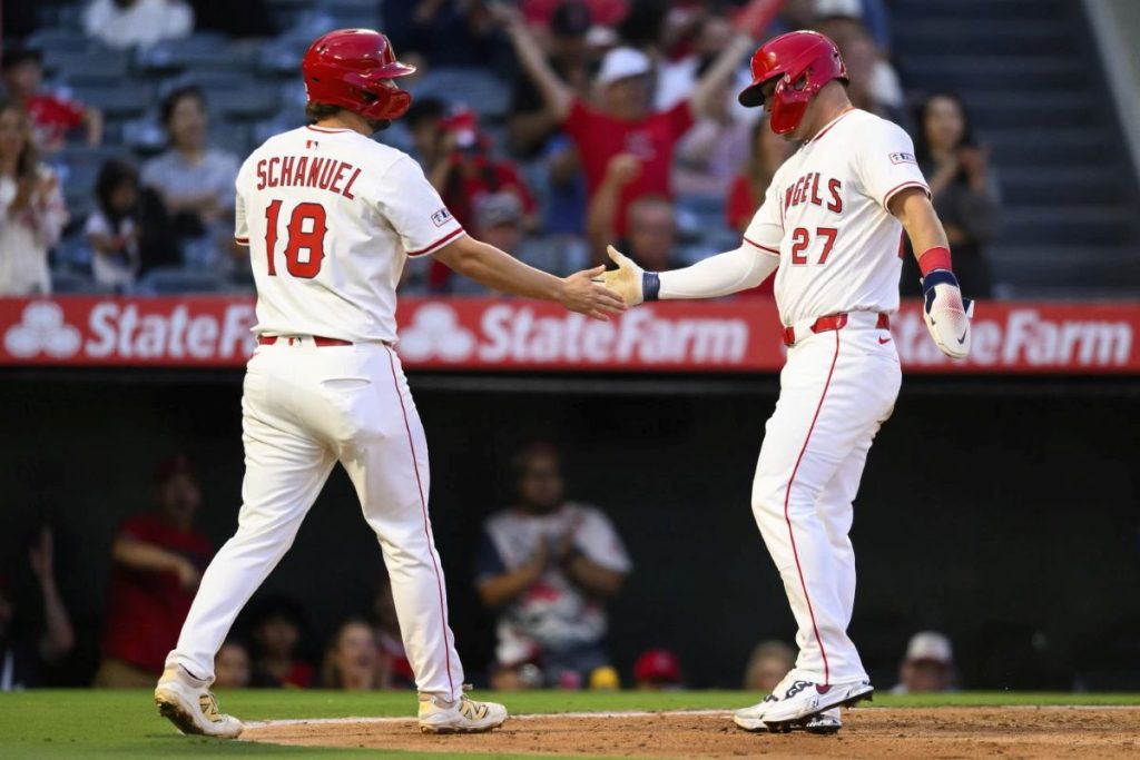 Los Angeles Angels' Mike Trout, right, and Nolan Schanuel, left, greet each other after scoring during the third inning of a baseball game against the Tampa Bay Rays, Monday, Aug. 4, 2025, in Anaheim, Calif. (AP Photo/William Liang)