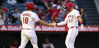 Los Angeles Angels' Mike Trout, right, and Nolan Schanuel, left, greet each other after scoring during the third inning of a baseball game against the Tampa Bay Rays, Monday, Aug. 4, 2025, in Anaheim, Calif. (AP Photo/William Liang)