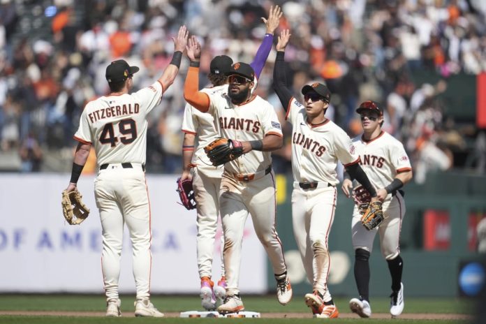 San Francisco Giants ' Tyler Fitzgerald, left, celebrates with Willy Adames, middle rear, Heliot Ramos, middle, Jung Hoo Lee, second from right, and Drew Gilbert after a baseball game against the Tampa Bay Rays in San Francisco, Sunday, Aug. 17, 2025. (AP Photo/Jeff Chiu)