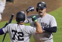 New York Yankees' Austin Wells (28) celebrates with José Caballero (72) after Wells hit a home run off Tampa Bay Rays pitcher Pete Fairbanks during the 10th inning of a baseball game Wednesday, Aug. 20, 2025, in Tampa, Fla. (AP Photo/Chris O'Meara)