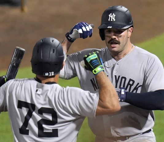 New York Yankees' Austin Wells (28) celebrates with José Caballero (72) after Wells hit a home run off Tampa Bay Rays pitcher Pete Fairbanks during the 10th inning of a baseball game Wednesday, Aug. 20, 2025, in Tampa, Fla. (AP Photo/Chris O'Meara)