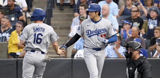 Los Angeles Dodgers' Will Smith (16) and Shohei Ohtani (17) score on a double by Freddie Freeman (not pictured) during the first inning of a baseball game against the Tampa Bay Rays Friday, Aug. 1, 2025, in Tampa, Fla. (AP Photo/Jason Behnken)