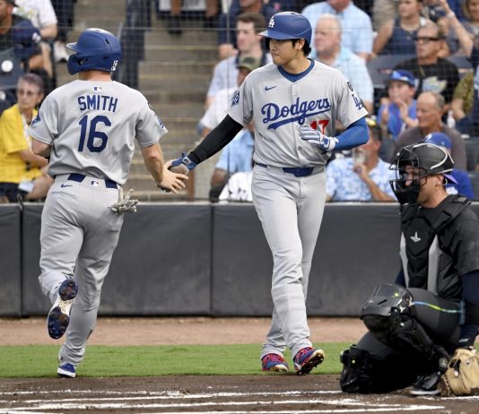 Los Angeles Dodgers' Will Smith (16) and Shohei Ohtani (17) score on a double by Freddie Freeman (not pictured) during the first inning of a baseball game against the Tampa Bay Rays Friday, Aug. 1, 2025, in Tampa, Fla. (AP Photo/Jason Behnken)