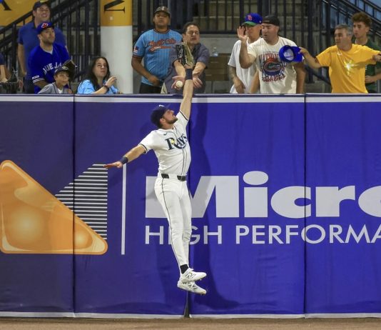 Tampa Bay Rays outfielder Josh Lowe jumps for a hit by Toronto Blue Jays' Nathan Lukes that was eventually ruled a home run after review during the fourth inning of a baseball game Tuesday, Sept. 16, 2025, in Tampa, Fla. (AP Photo/Mike Carlson)