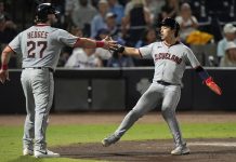 Cleveland Guardians' Austin Hedges (27) and Steven Kwan celebrate after scoring on a two-run double by José Ramírez off Tampa Bay Rays pitcher Ian Seymour during the second inning of a baseball game Friday, Sept. 5, 2025, in Tampa, Fla. (AP Photo/Chris O'Meara)