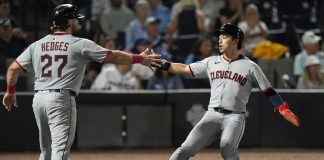 Cleveland Guardians' Austin Hedges (27) and Steven Kwan celebrate after scoring on a two-run double by José Ramírez off Tampa Bay Rays pitcher Ian Seymour during the second inning of a baseball game Friday, Sept. 5, 2025, in Tampa, Fla. (AP Photo/Chris O'Meara)