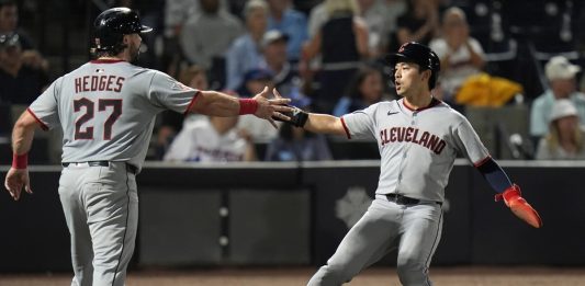 Cleveland Guardians' Austin Hedges (27) and Steven Kwan celebrate after scoring on a two-run double by José Ramírez off Tampa Bay Rays pitcher Ian Seymour during the second inning of a baseball game Friday, Sept. 5, 2025, in Tampa, Fla. (AP Photo/Chris O'Meara)