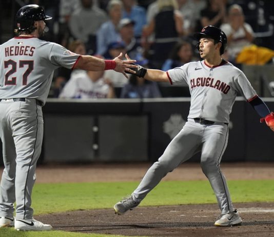 Cleveland Guardians' Austin Hedges (27) and Steven Kwan celebrate after scoring on a two-run double by José Ramírez off Tampa Bay Rays pitcher Ian Seymour during the second inning of a baseball game Friday, Sept. 5, 2025, in Tampa, Fla. (AP Photo/Chris O'Meara)