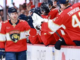 Carter Verhaeghe #23 of the Florida Panthers high fives teammates after scoring against the Chicago Blackhawks during the first period at Amerant Bank Arena on October 07, 2025 in Sunrise, Florida.
