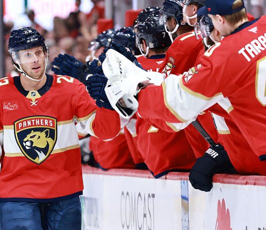 Carter Verhaeghe #23 of the Florida Panthers high fives teammates after scoring against the Chicago Blackhawks during the first period at Amerant Bank Arena on October 07, 2025 in Sunrise, Florida.