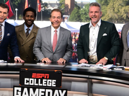 Nick Saban smiling on the ESPN College GameDay set in Tuscaloosa, wearing a suit and headset.